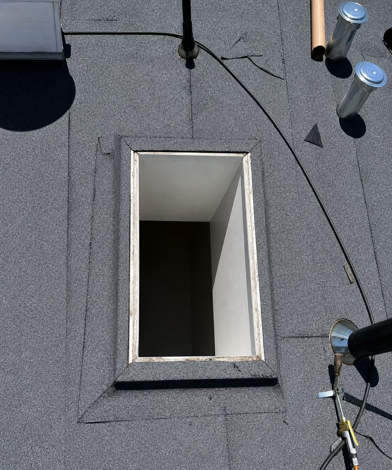 Low-slope roof membrane being installed around a roof opening in Santa Clara