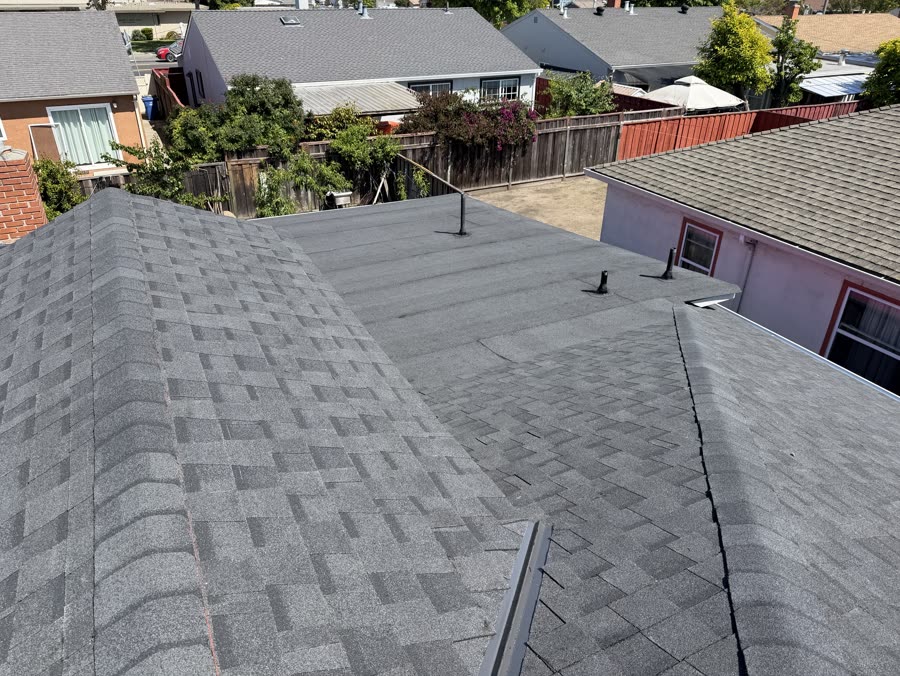 Transition between a low-slope roof section and shingled slope on a Bay Area home