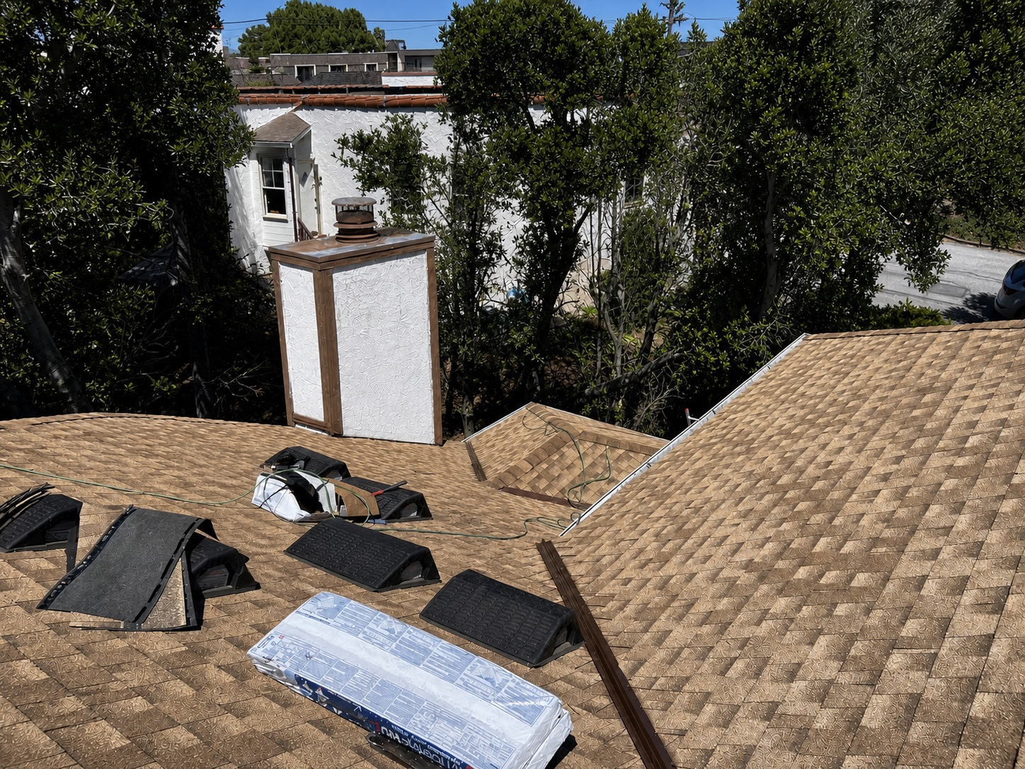 Roofing tools and shingle bundles on a Belmont roof during installation